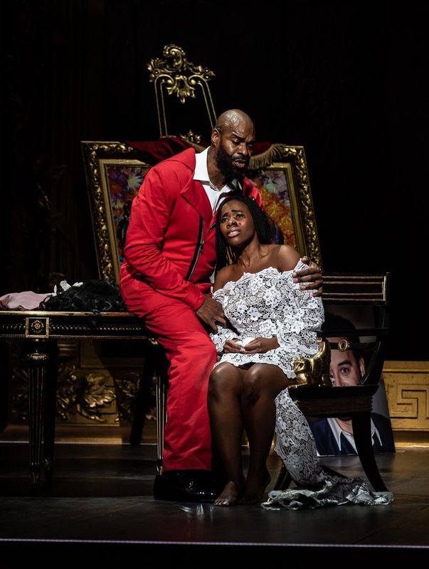 A person in a red outfit is comforting another person in a white dress