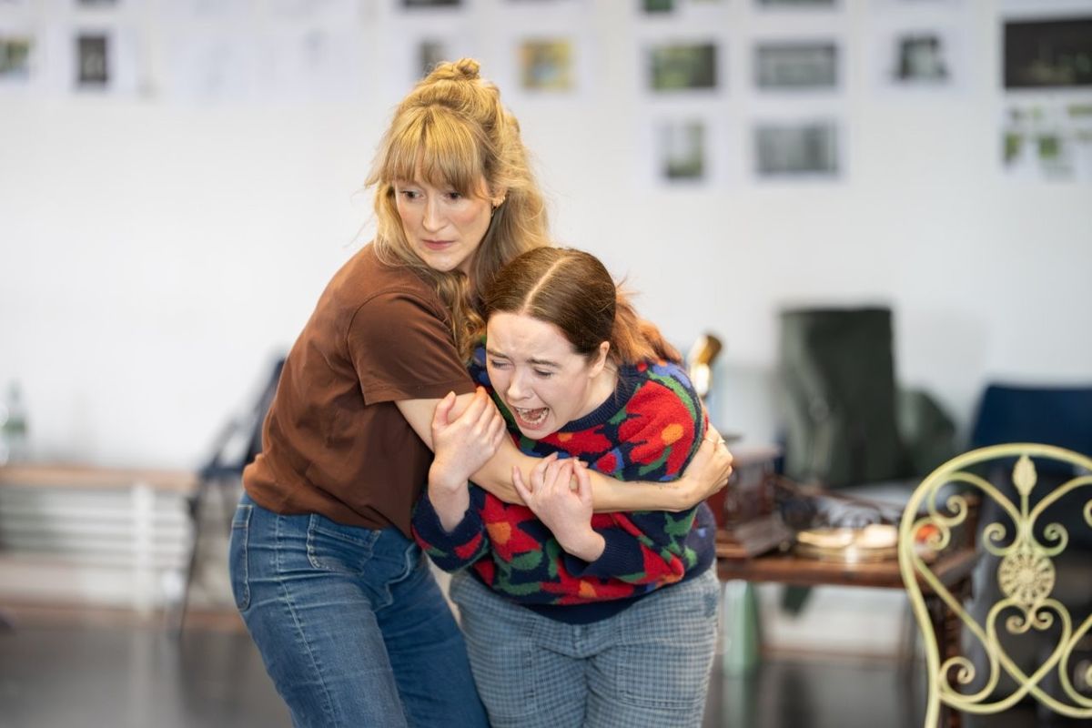 A woman holding another woman as she cries