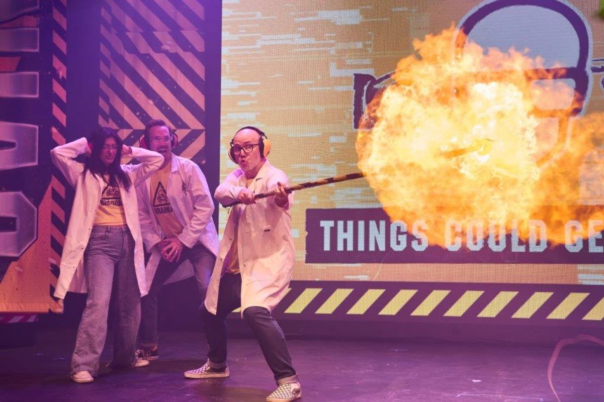 Three people look over a giant fireball.