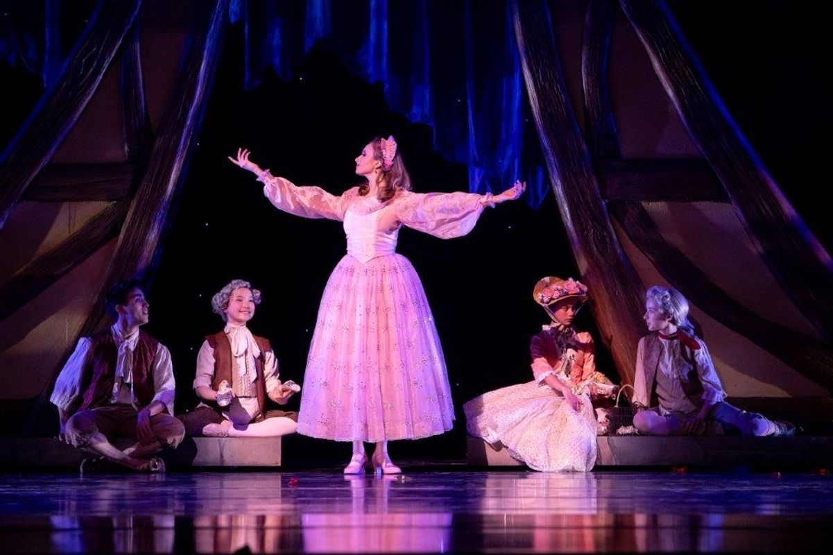 The Milwaukee Company dancing on stage for the production of Northern Ballet Cinderella. The are wearing Victorian styles costumes and are moving elegantly.