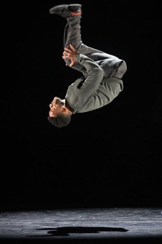A person in captured mid back flip with their feet in the air.