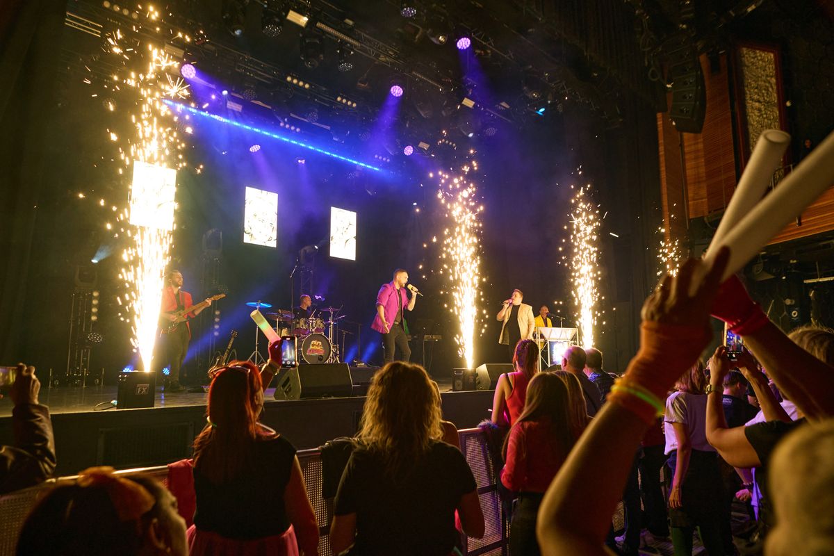 Four cannons fire out sparks at the front of the stage.