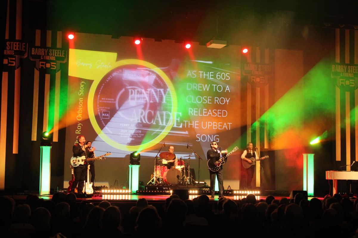 The band play covered in green and orange lights.