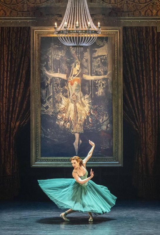 A dancer dressed in green twists their lower body.