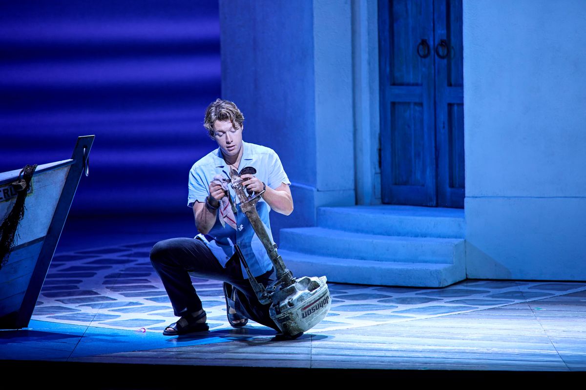 Sky kneels by a boat.