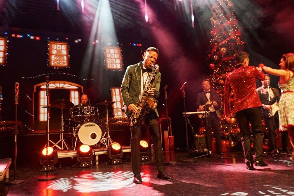 A saxophonist plays on stage. 