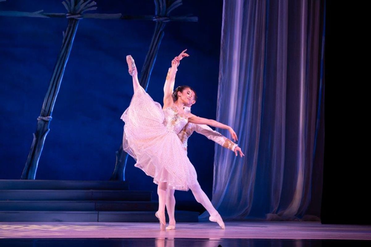 The Milwaukee Company dancing on stage for the production of Northern Ballet Cinderella. The are wearing Victorian styles costumes and are moving elegantly.