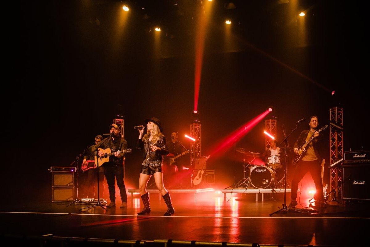 Country singers performing on stage wearing cowboy hats and playing instruments