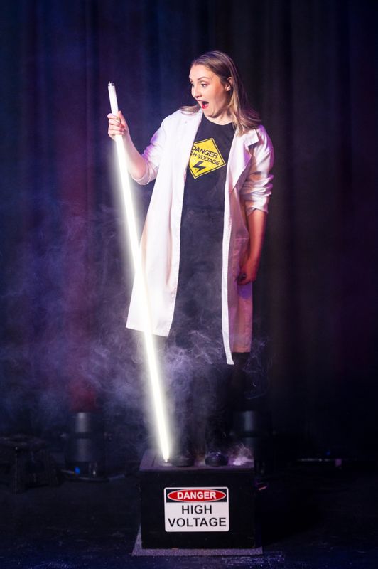A person stands on a box looking at a laser.