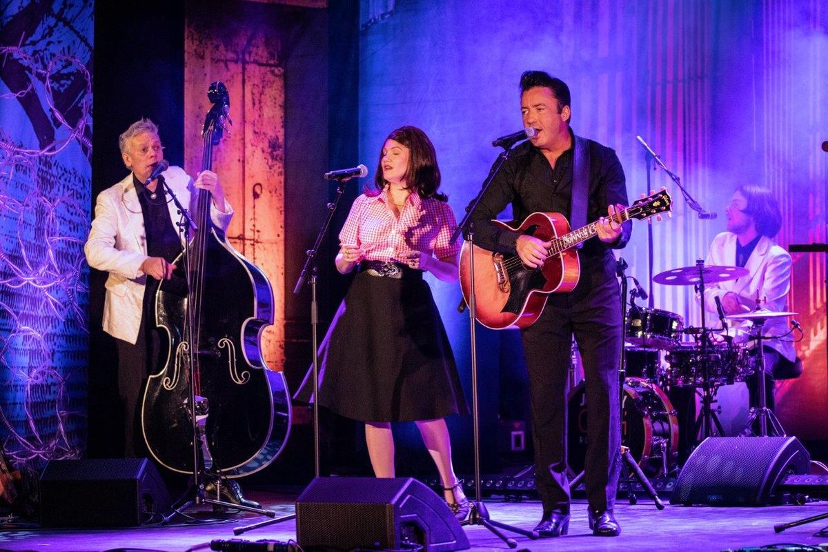 Johnny Cash Roadshow and band performing on stage.