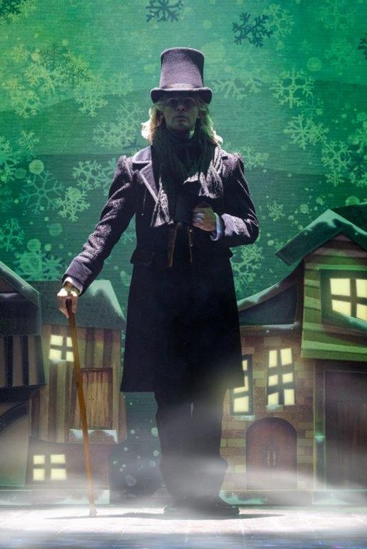 A person wearing a black coat and top hat  looks out ominously surrounded by haze.