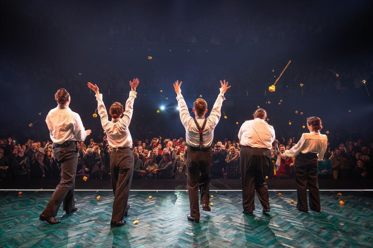 The back of 5 people, they are looking out to the audience.