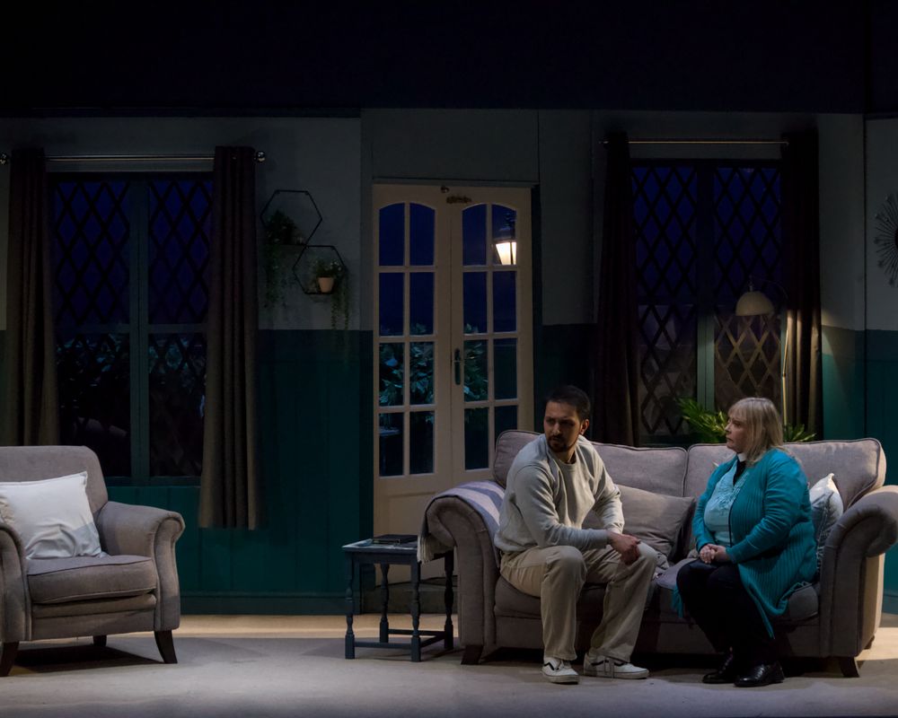 Two people sat on the sofa talking