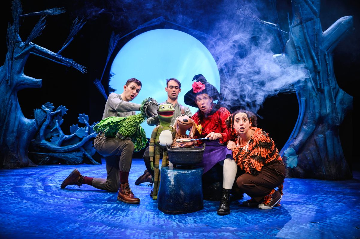 Group of actors onstage with animal puppets.