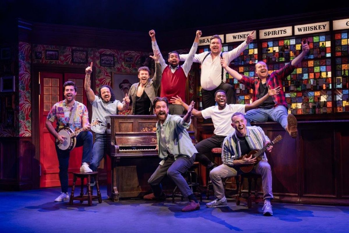 A group of people stood around a piano