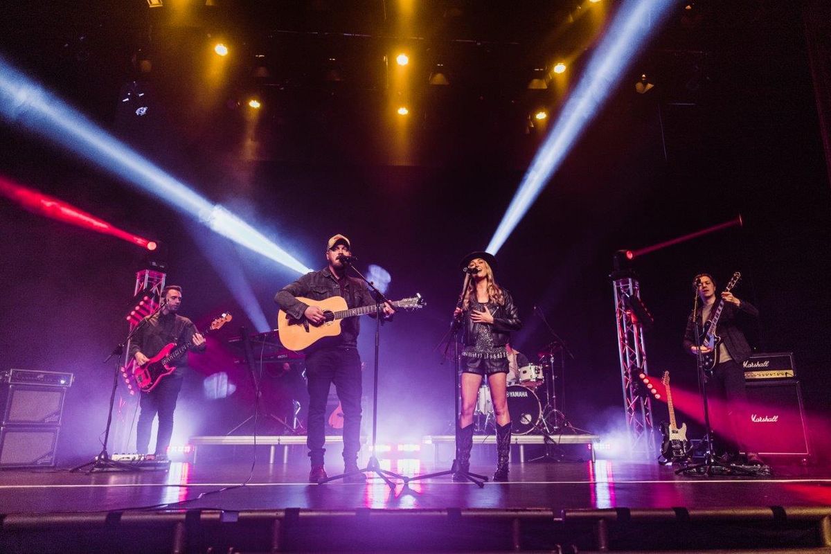 Country singers performing on stage wearing cowboy hats and playing instruments