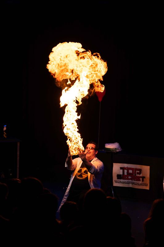 A person stands looking at fire.