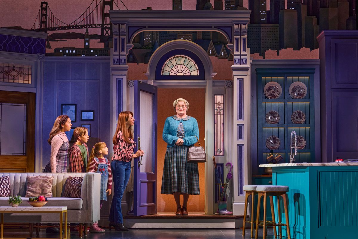 Mrs Doubtfire stands in the doorway greeted by Miranda and the three children.