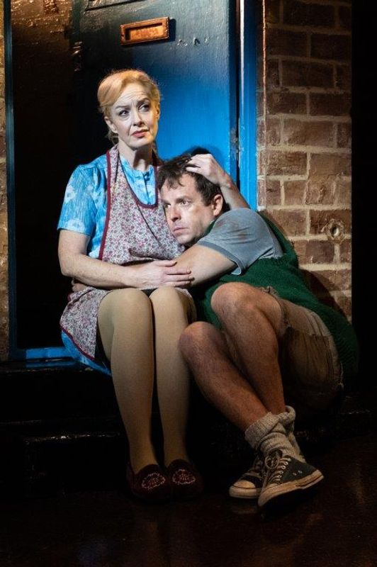 A woman is embracing and comforting her son on a doorstep