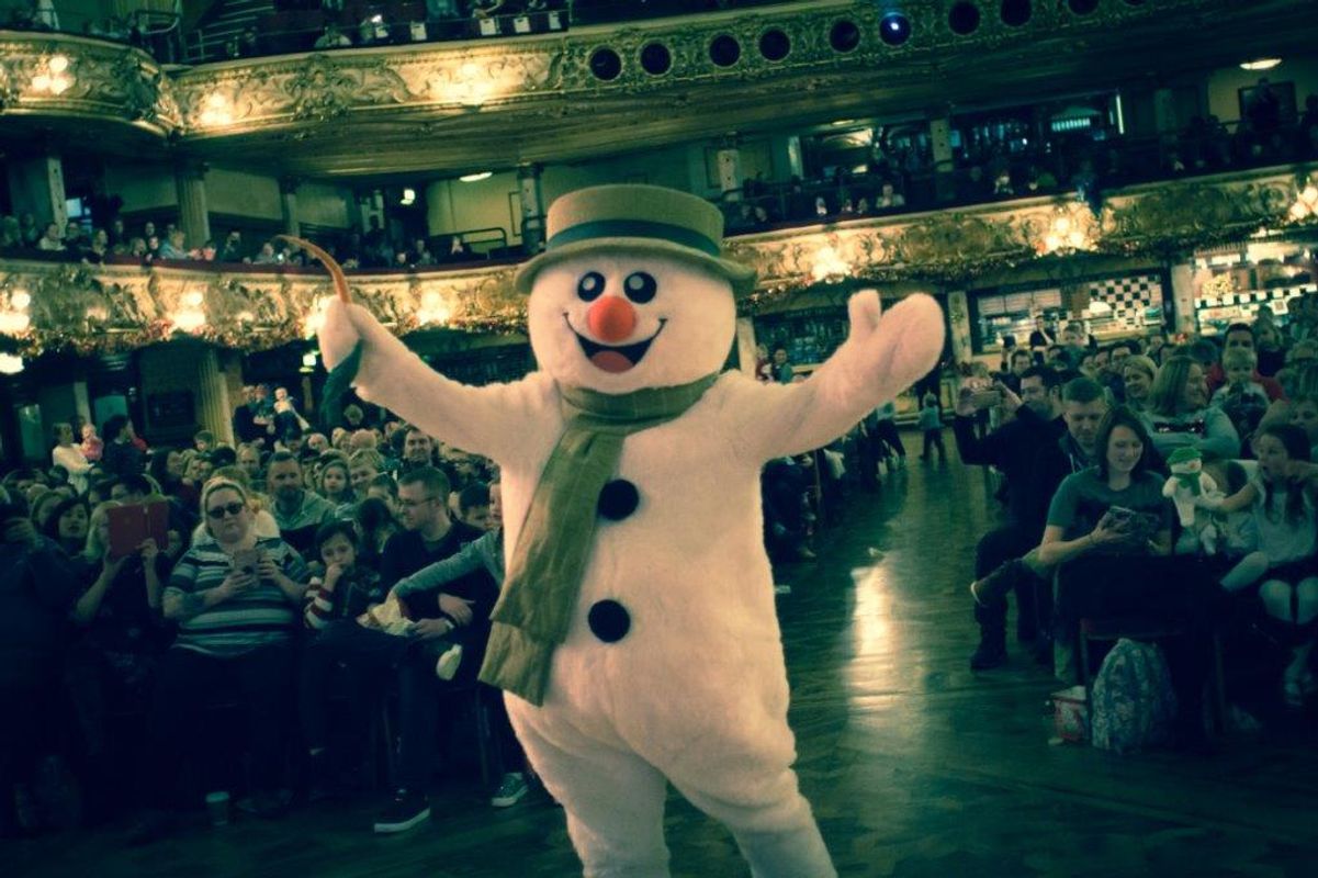 Someone dressed as The Snowman and the audience are in the background