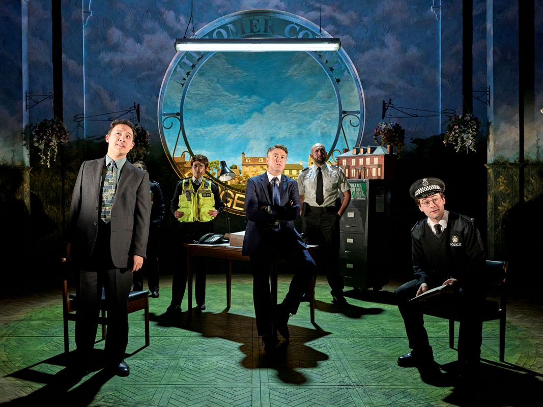 Five police officers stand on stage.