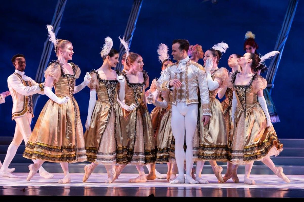 The Milwaukee Company dancing on stage for the production of Northern Ballet Cinderella. The are wearing Victorian styles costumes and are moving elegantly.