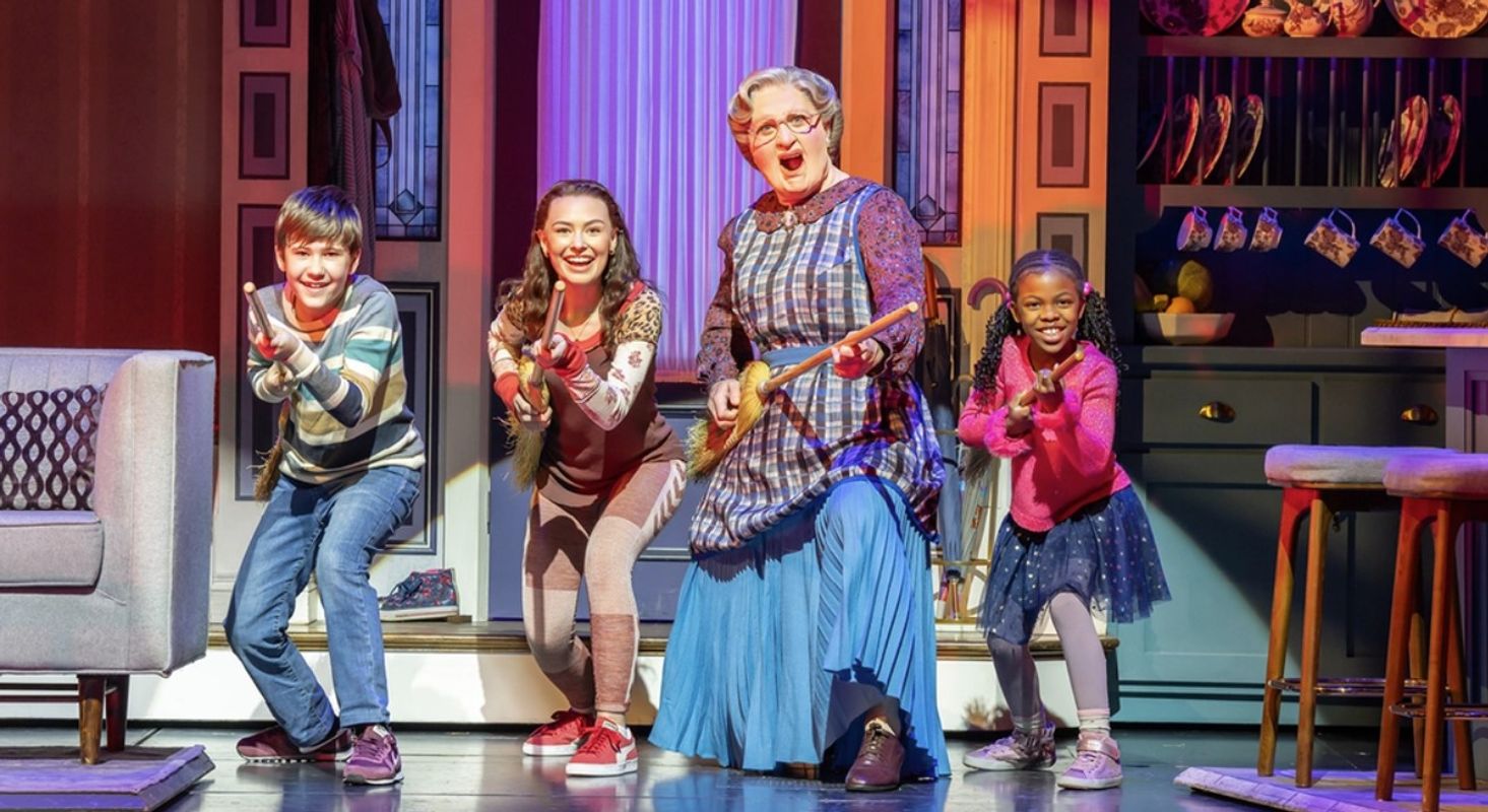 Mrs Doubtfire and Three children are using mops and brooms as guitars