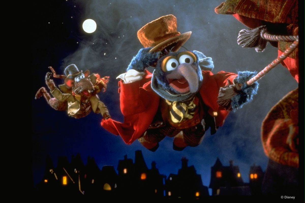 Two puppets are flying through the air by holding onto one of the christmas ghosts