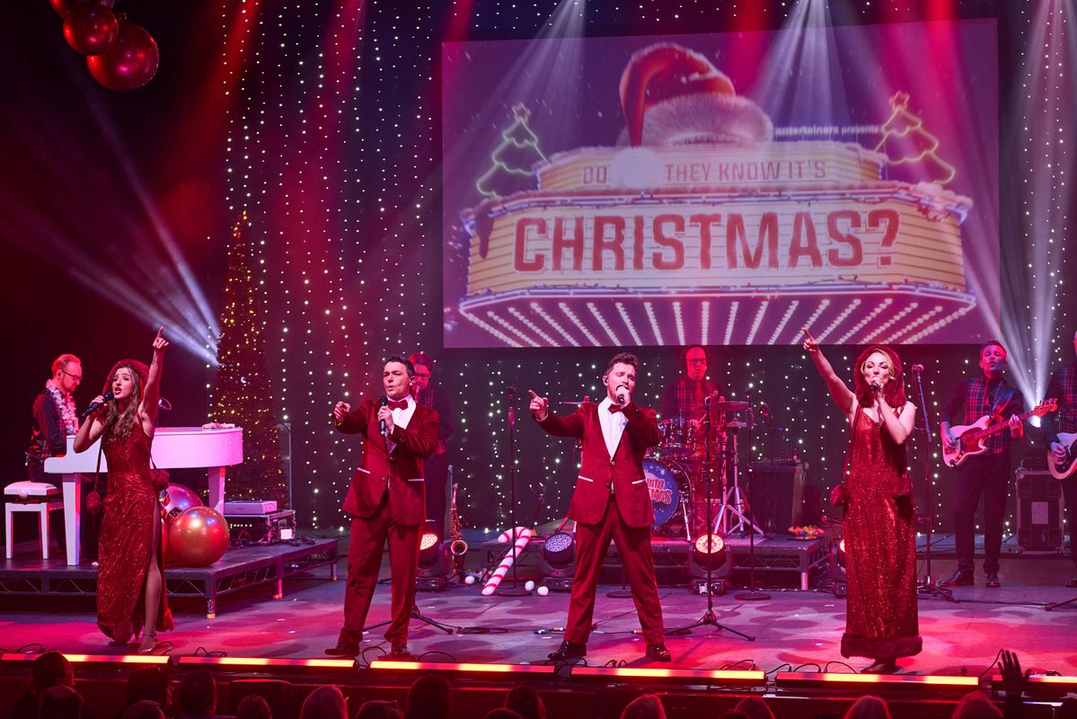 Performers on stage singing and dancing in a Christmas scene