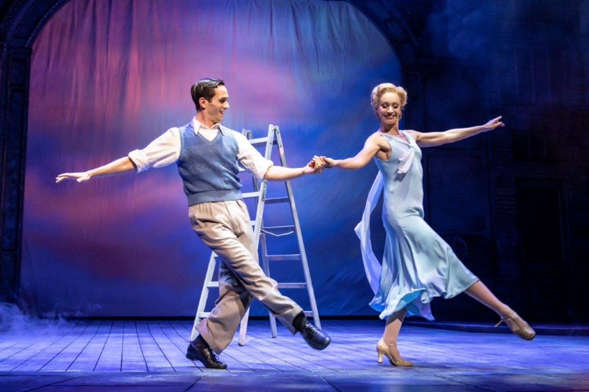 A man and a woman dancing together and there is a ladder behind them