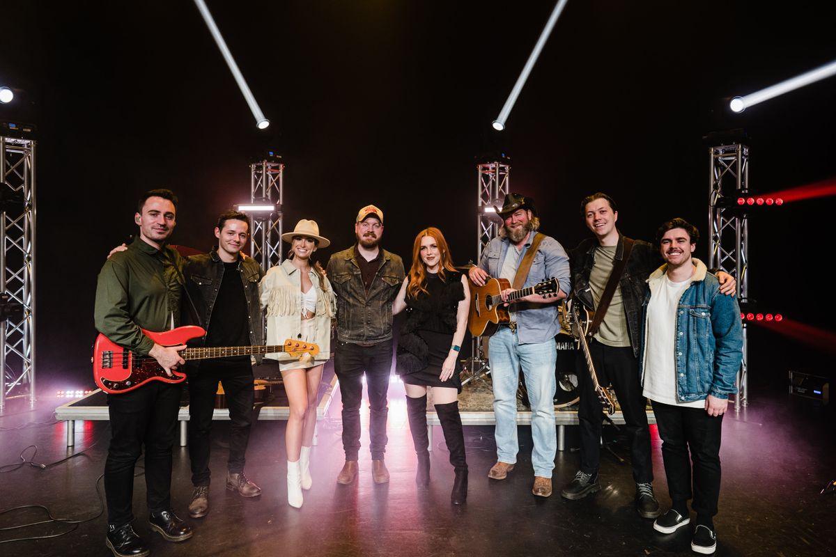 Eight band members smile to the camera.