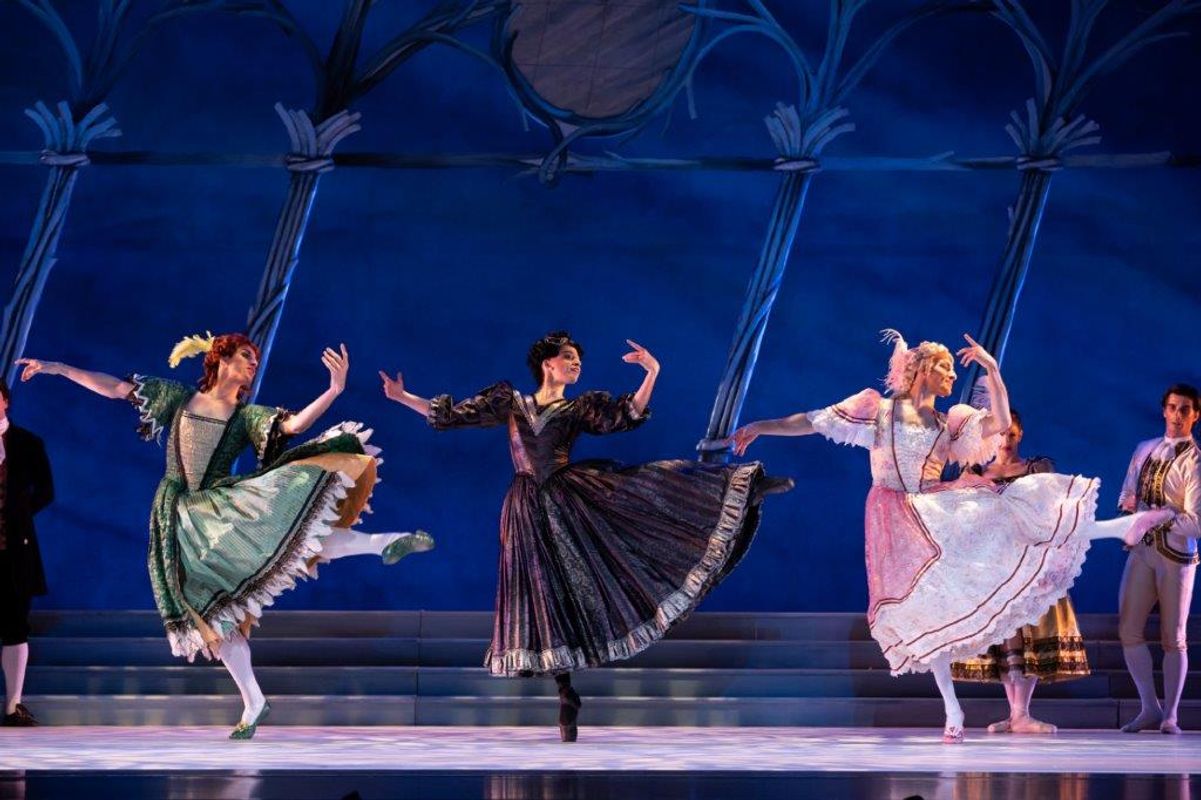 The Milwaukee Company dancing on stage for the production of Northern Ballet Cinderella. The are wearing Victorian styles costumes and are moving elegantly.