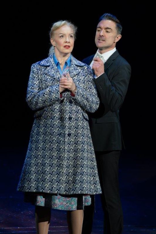 A man and a woman are stood together, he looks to be talking to her